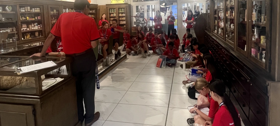 Dr Tong talks with PharmCamp students during a museum tour