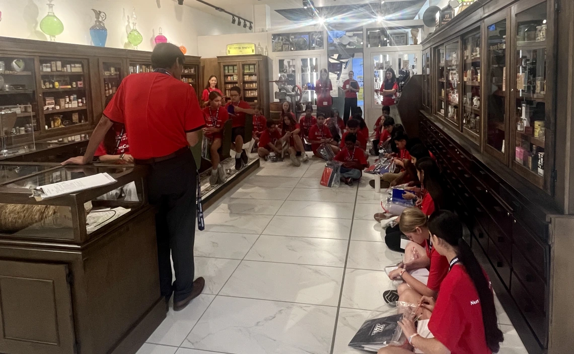 Dr Tong talks with PharmCamp students during a museum tour