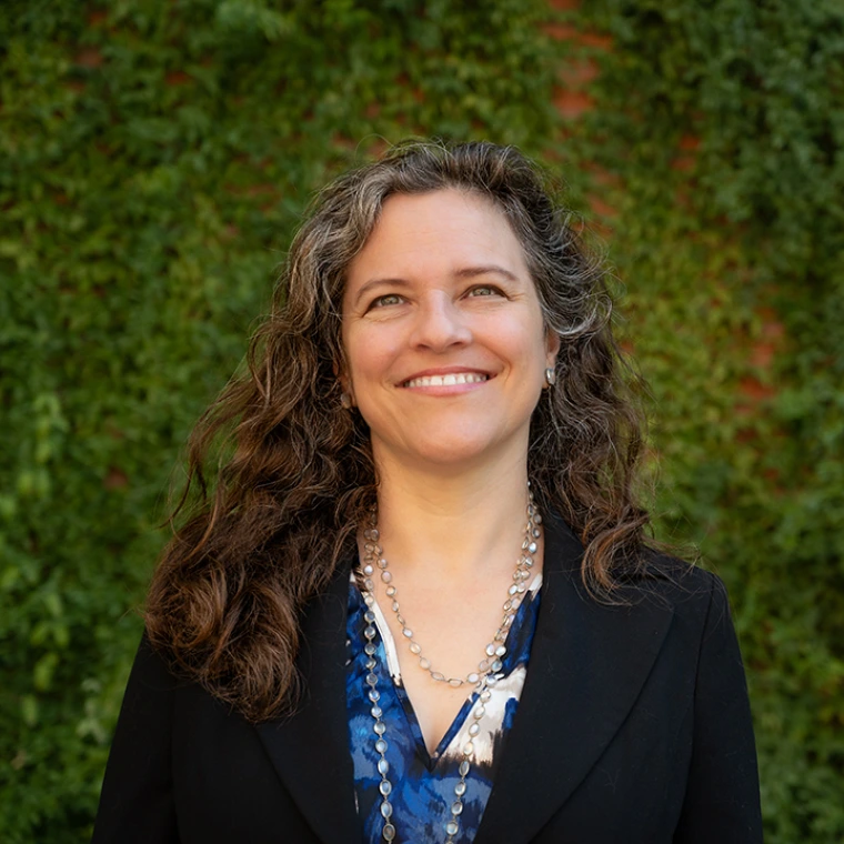 Heather Ingram, Director of Coit Museum of Pharmacy and Health Sciences stands in from of greenery in a formal portrait.